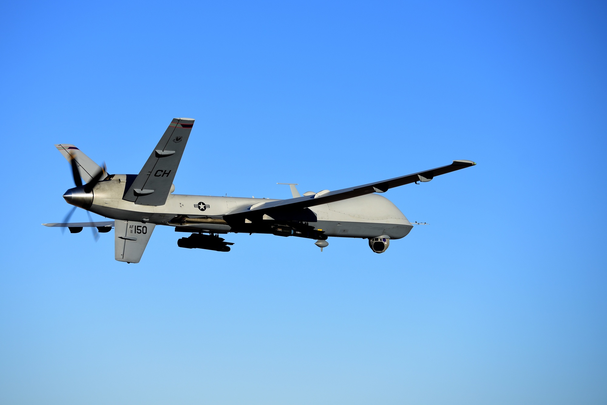 MQ-9 Reaper in flight against a clear blue sky