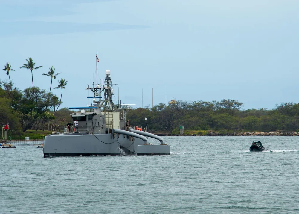 Sea Hunter unmanned trimaran arriving at Pearl Harbor with its sensor mast above the central hull